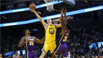 Golden State Warriors forward Alen Smailagic (6) shoots the ball between Los Angeles Lakers center Dwight Howard (39) and guard Troy Daniels (30)