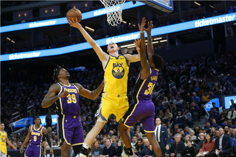 Golden State Warriors forward Alen Smailagic (6) shoots the ball between Los Angeles Lakers center Dwight Howard (39) and guard Troy Daniels (30)
