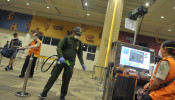 A medical officer sprays disinfectant on an entrance gate at the international terminal of I Gusti Ngurah Rai airport.