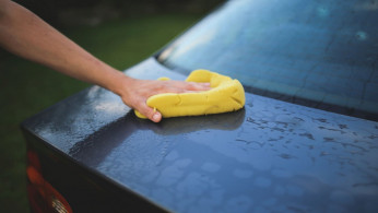 Washing a car with sponge.