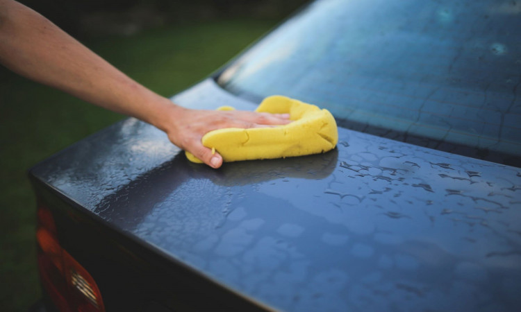 Washing a car with sponge.