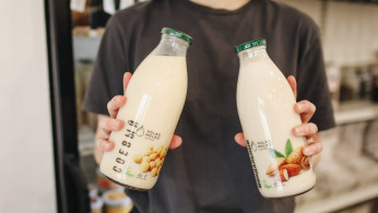 Person holding milk bottles.