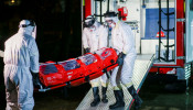 Health workers wearing protective suits transport a patient infected with coronavirus inside a hospital in Timisoara