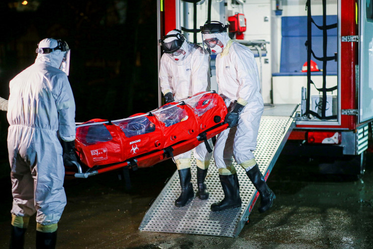 Health workers wearing protective suits transport a patient infected with coronavirus inside a hospital in Timisoara