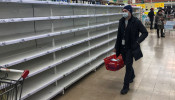 A man, wearing a protective mask, walks past empty shelves in a store, due to the fear of coronavirus disease (COVID-19) outbreak, in Moscow