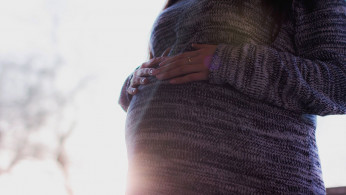 Pregnant woman wearing sweater.