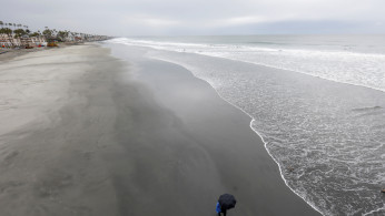 A man walks along an empty beach during the global outbreak of the coronavirus disease (COVID-19) in Oceanside, California,