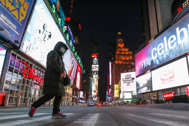 A person in a face mask walks through an almost empty Times Square as the coronavirus disease (COVID-19) outbreak continued in Manhattan, New York City