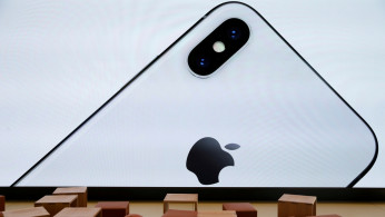 An iPhone X is seen on a large video screen in the new Apple Visitor Center in Cupertino