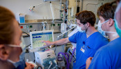 Doctors receive instructions for a respirator system at the intensive care unit of the University Medical Center Hamburg-Eppendorf in Hamburg, Germany