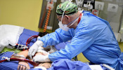 A member of the medical staff in a protective suit treats a patient suffering from coronavirus disease (COVID-19) in an intensive care unit at the San Raffaele hospital in Milan