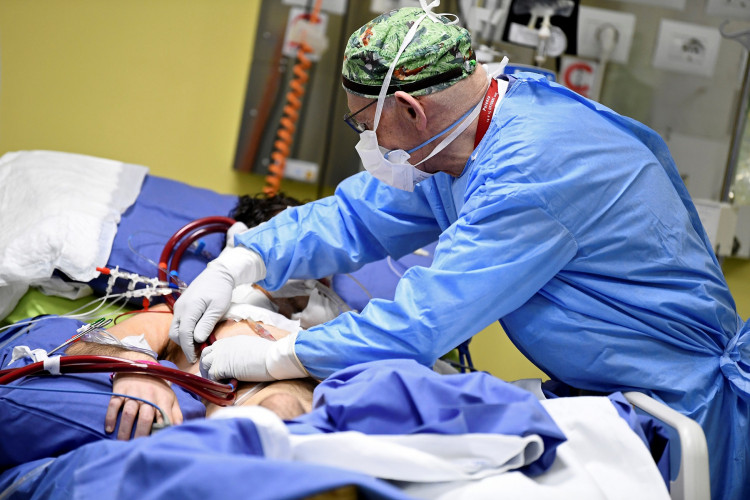A member of the medical staff in a protective suit treats a patient suffering from coronavirus disease (COVID-19) in an intensive care unit at the San Raffaele hospital in Milan