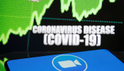 Zoom logo is seen in front of displayed coronavirus disease (COVID-19)