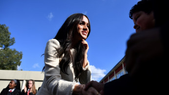 Britain's Meghan, Duchess of Sussex, smiles as she is welcomed by students to visit the Robert Clack School in Essex