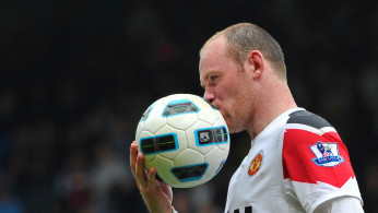 FILE PHOTO: Manchester United striker Wayne Rooney kisses the ball after scoring a hat-trick in a 4-2 Premier League victory over West Ham United at Upton Park
