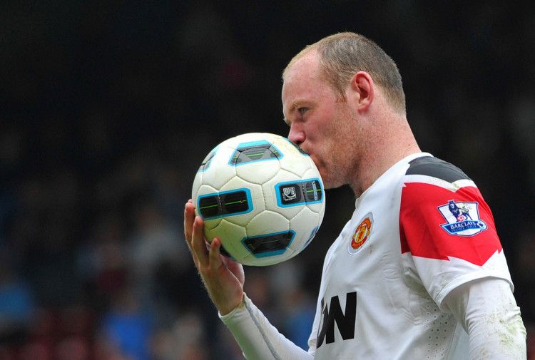 FILE PHOTO: Manchester United striker Wayne Rooney kisses the ball after scoring a hat-trick in a 4-2 Premier League victory over West Ham United at Upton Park
