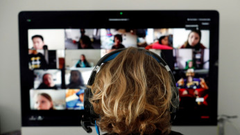 A student takes classes online with his companions using the Zoom APP at home