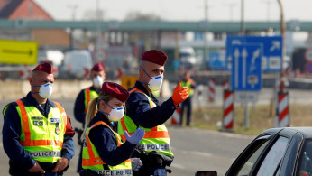  Hungarian police officers gesture while the Hungarian-Austrian border is closed, as the spread of the coronavirus disease (COVID-19) continues, near Nickelsdorf