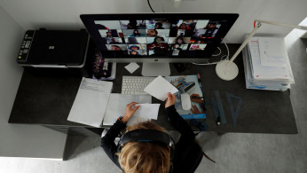 A student takes classes online with his companions using the Zoom APP at home