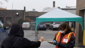 An election official takes a voter's driver's license information during the presidential primary election held amid the coronavirus disease (COVID-19) outbreak in New Richmond