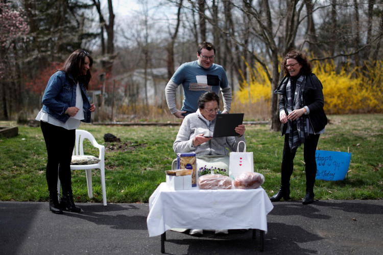 Sisters Sylvia (R) and Stephanie Falcomer hold a "socially distant" 94th birthday party for their mother Marcella Falcomer in Wet Nyack