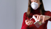 Woman applying hand sanitizer.