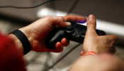 A man uses a Sony PlayStation controller during the Gamescom 2015 fair in Cologne