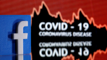 A 3D printed Facebook logo is seen in front of displayed coronavirus disease (COVID-19) words in this illustration