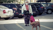 Elderly woman walking dog.