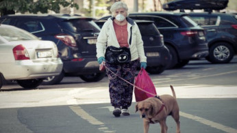 Elderly woman walking dog.