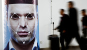 People walk past a poster simulating facial recognition software at an exhibition in Beijing, China 