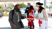 A Red Cross volunteer checks temperature of a customer at the entrance of an open-air food market that has been reopened, during the coronavirus disease (COVID-19) outbreak in Cisternino