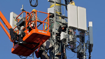 A contract crew from Verizon installs 5G equipment on a tower in Orem