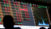 FILE PHOTO: People look at an electronic board showing the graph of fluctuations of market indices at the floor of Brazil's BM&F Bovespa Stock Market in downtown Sao Paulo