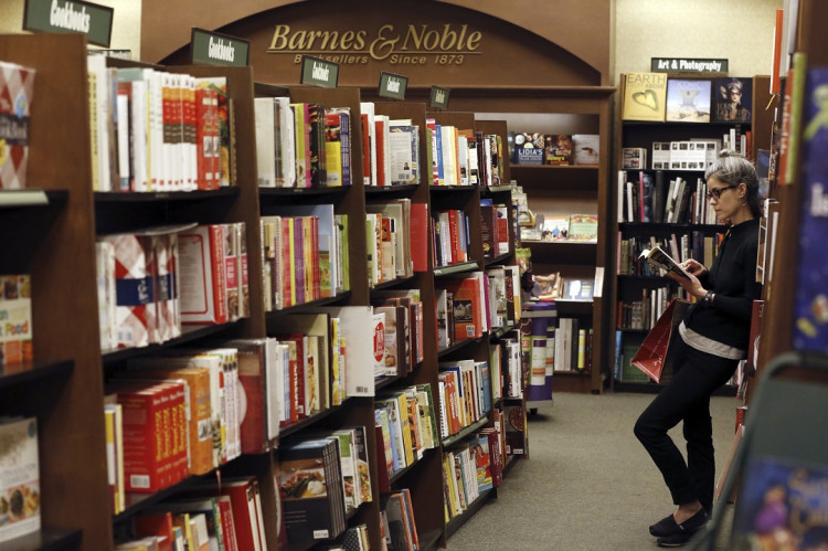 A woman reads a book at a Barnes & Noble bookstore in Pasadena, California November 26, 2013.
