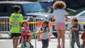 Children play while families wait in line at a food bank at St. Bartholomew Church, during the outbreak of the coronavirus disease (COVID-19) in the Elmhurst section of Queens, New York City