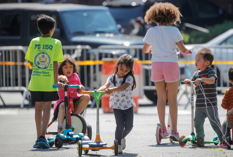 Children play while families wait in line at a food bank at St. Bartholomew Church, during the outbreak of the coronavirus disease (COVID-19) in the Elmhurst section of Queens, New York City