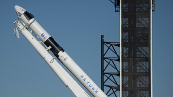 A SpaceX Falcon 9 rocket with the company's Crew Dragon spacecraft onboard is raised into a vertical position on the launch pad at Launch Complex 39A at NASA’s Kennedy Space Center