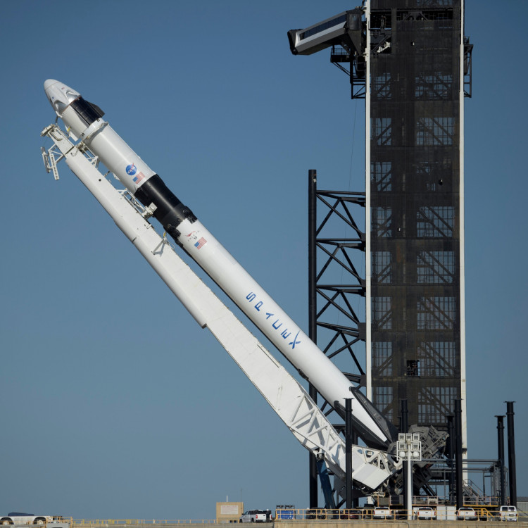 A SpaceX Falcon 9 rocket with the company's Crew Dragon spacecraft onboard is raised into a vertical position on the launch pad at Launch Complex 39A at NASA’s Kennedy Space Center