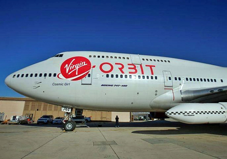 Richard Branson's Virgin Orbit, with a rocket underneath the wing of a modified Boeing 747 jetliner