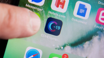 A man uses a Swedish version of the Covid Symptom Tracker app on his smartphone as the spread of the coronavirus disease (COVID-19) continues, in Stockholm