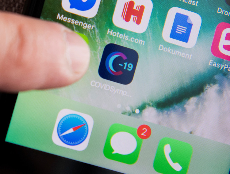 A man uses a Swedish version of the Covid Symptom Tracker app on his smartphone as the spread of the coronavirus disease (COVID-19) continues, in Stockholm