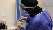 A member of the medical team wears a protective suit as she collects blood specimens at a testing center for coronavirus disease (COVID-19), in Tehran, Iran, May 20, 2020. 
