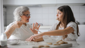 Grandmother and granddaughter bonding while baking. 