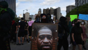 A protestor holds a photo of George Floyd during a protest against the death in Minneapolis police custody of African-American man George Floyd