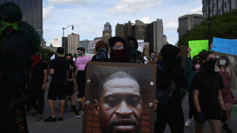 A protestor holds a photo of George Floyd during a protest against the death in Minneapolis police custody of African-American man George Floyd