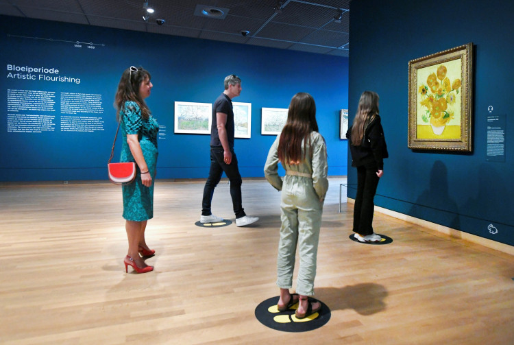 People look at Vincent van Gogh's Sunflowers painting at the Van Gogh Museum that reopened as Netherlands eases some of the lockdown measures