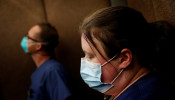 Traveling nurse Meghan Lindsey looks down wearing a protective face mask after her shift on Mother’s Day in her hotel elevator hotel in the Queens borough of New York