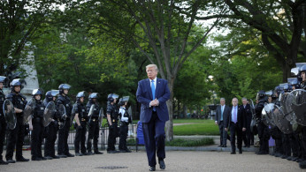 U.S. President Trump walks between lines of riot police in Washington