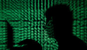 A man holds a laptop computer as cyber code is projected on him in this illustration picture